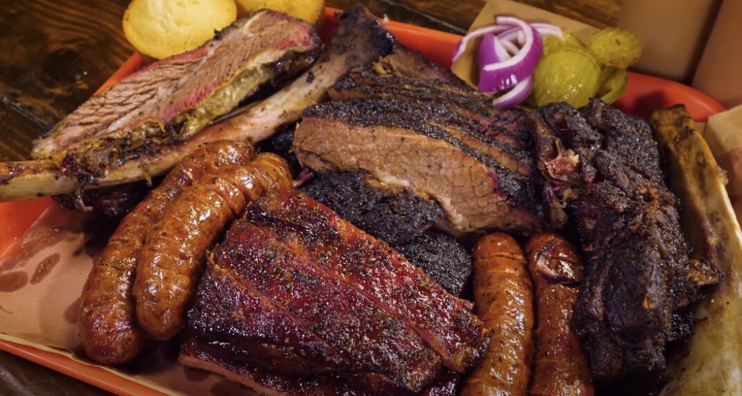 Assorted Texas BBQ dishes on a wooden platter.